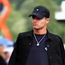 Lando lo mantiene elegante en un ajuste completamente negro, combinando una gorra de cuadrante con ropa de calle en capas