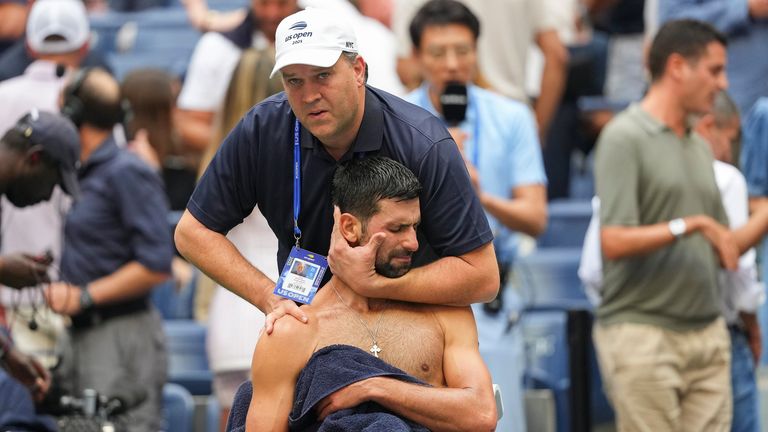 El entrenador atlético Clay Sniteman trabaja en Novak Djokovic entre sets durante el partido de semifinales abiertos de los Estados Unidos contra Carlos Alcaraz