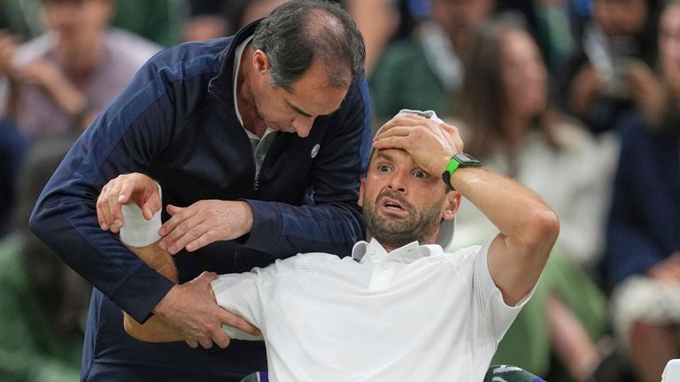 El búlgaro Grigor Dimitrov recibe tratamiento después de sufrir una lesión que le obligó a retirarse lesionado de un pecado masculino en el cuarto asalto.