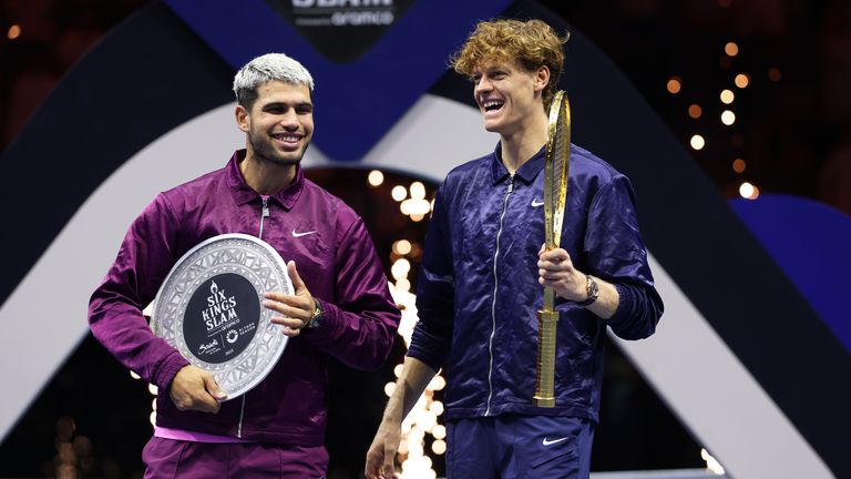 Jannik Sinner de Italia (R) y Carlos Alcaraz de España comparten una broma después de recibir sus trofeos después de la final individual masculina el día thr